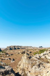 Dry and wide erosional landscape with rocks and trees