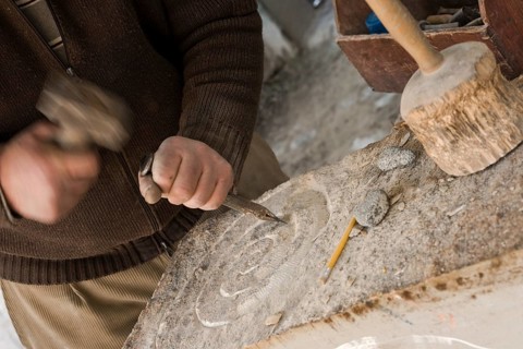 Sculptor chisels the stone