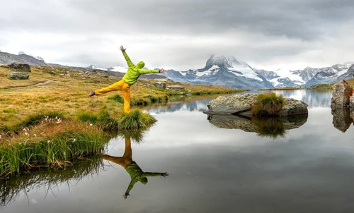 Hiker stretches his arms into the air