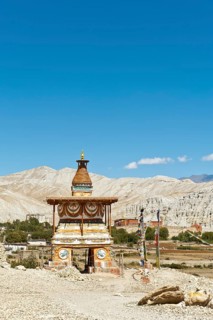 Colourfully decorated Buddhist stupa at the entrance to the village