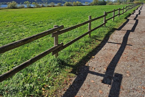 Fence with a shadow along the promenade path