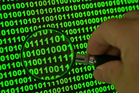 Binary code viewed through a magnifying glass