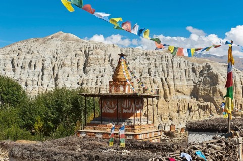 Colorful ornate Buddhist stupa with colorful prayer flags