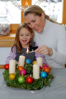 Mother and daughter lighting the first candle on the Advent wreath