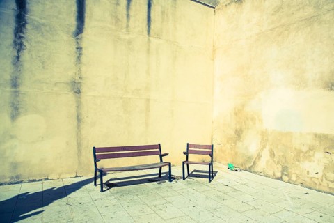 Chair and bench in front of house wall