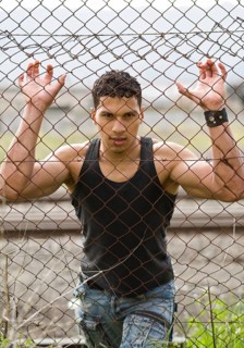 Young man holding onto a fence