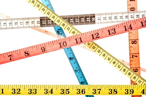 Various colourful tape measures criss-crossing over each other