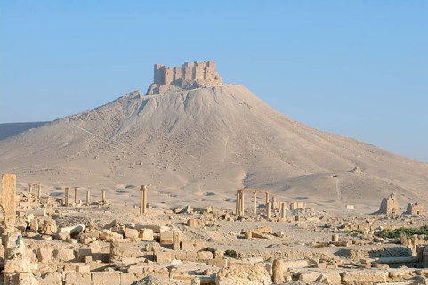 The ruins of the ancient city Palmyra in front of a medieval fortress