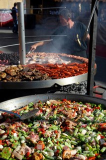 Large pan containing ingredients for the paella in front of a giant barbecue at the annual All Saints Market in Cocentaina