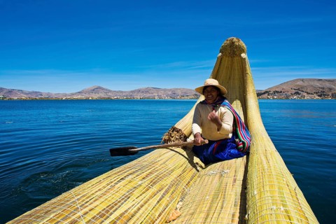Local in a traditional rowing boat of Totora reed on Lake Titicaca
