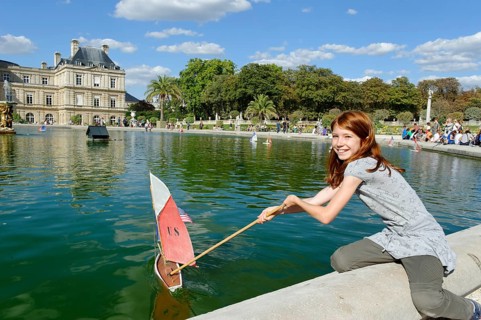 Girl playing with ship at the pond of the Palais du Luxembourg