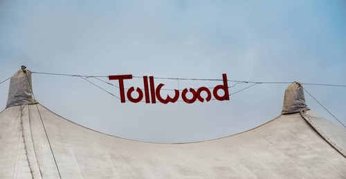 Sign 'Tollwood' above a tent roof