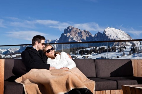 Man and woman sitting on a couch outdoors