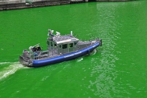 Police boat on the Chicago River green on St. Patrick's Day