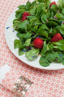 Cornsalad with strawberries and petals served on a plate