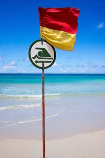 Dangerous beach with a flag indicating where bathing and swimming is possible