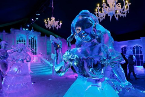 Female ice figure in front of a fairytale castle made of ice