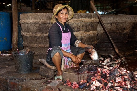 Woman chopping fish at the fish market