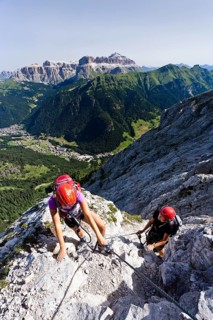Mountain climbers ascending along the Via ferrata dei Finanzieri climbing route to the summit of Colac Mountain in the Fassa Valley