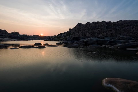 Sunset over Tungabhadra river and a part of the ruins of the former Vijayanagara Empire