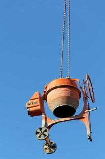 Concrete mixer hanging from a crane