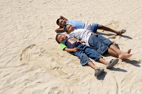 Three Kuna Indian boys lying in the sand