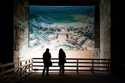 Visitors observing an aerial view of the airport in a large hall