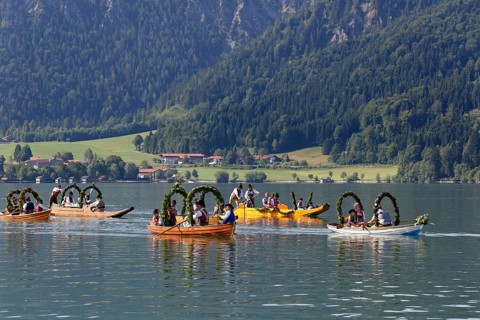 Locals wearing traditional costumes in decorated wooden Platte boats