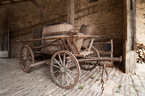Old hay cart with wine barrels in the courtyard of a wine press
