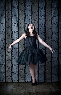 Girl wearing a black ballet dress screaming