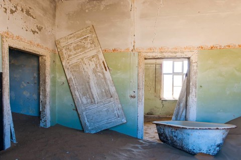 Wind-borne sand in a house of the former diamond miners settlement that is slowly covered by the sand of the Namib Desert