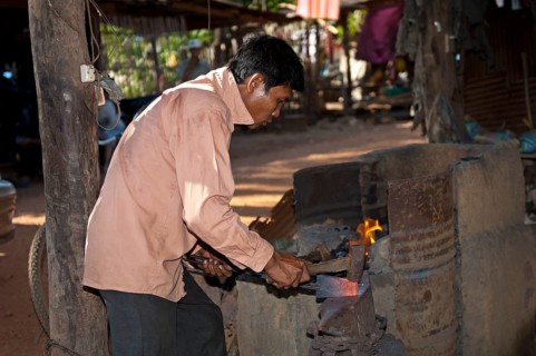 Blacksmith forging red-hot iron in a forge
