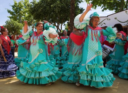 Women wearing gypsy dresses perform traditional Andalusian dances at the Feria del Caballo
