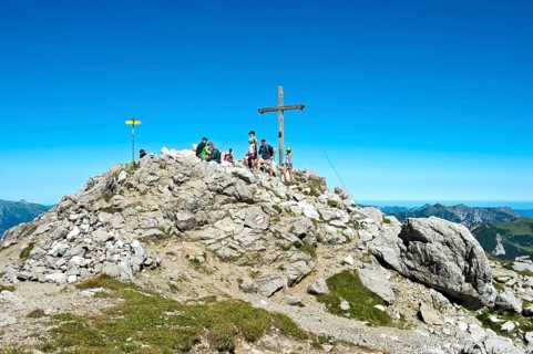 Rest at the summit cross on the Augstenberg mountain