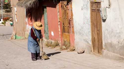 Woman sweeping outside her house