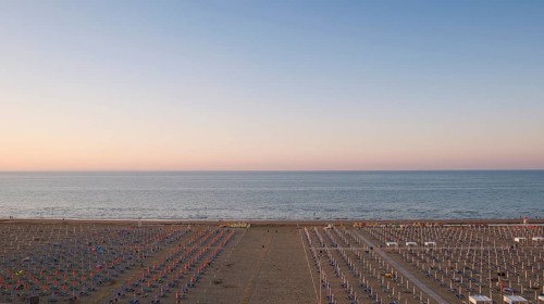 View of a beach with sunshades and sun beds