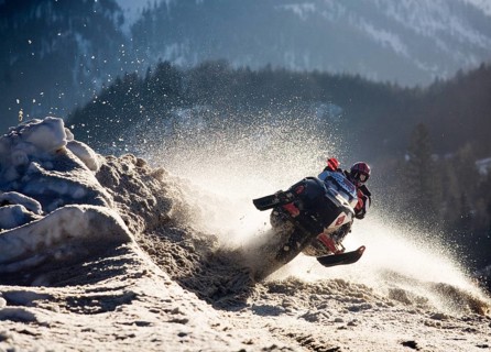 Snow mobile or ski-doo rider jumping into a curve