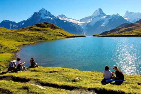 Walkers having a rest next to Bachalpsee lake near Grindelwald First