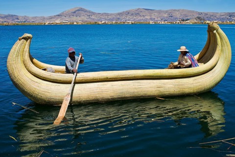 Two local in a traditional rowing boat of Totora reed on Lake Titicaca