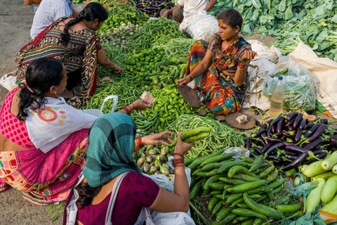 A woman is selling aubergines