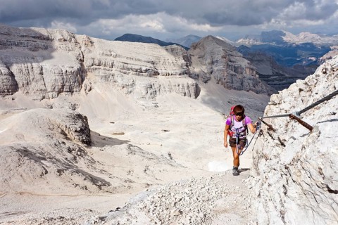 Mountain climber ascending Cunturines-Spitze Mountain in Fanes-Senes-Prague Nature Park