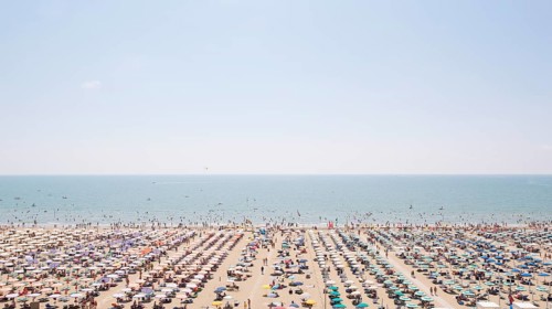 View of a beach with sunshades and sun beds
