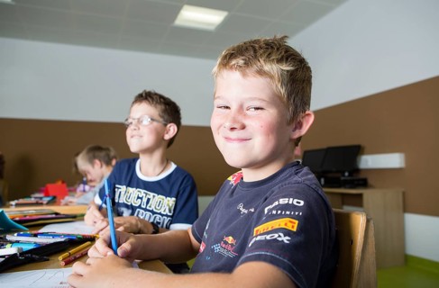 Children sitting in a primary school class during a drawing lesson