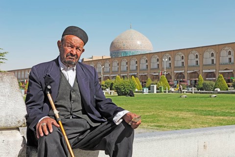 Muslim man in front of the dome of the Lotfollah Mosque