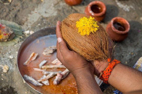 A man is holding a coconut during Dashkriya or Asthi Visarjan