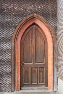 Side entrance with a shingled facade of the neo-Gothic Parish Church of St. Pelagius