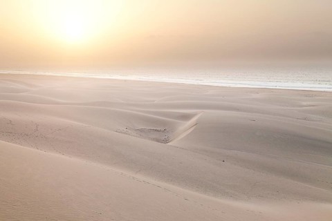 Sun in the mist of the sea above the sand dunes on Praia de Chaves Beach