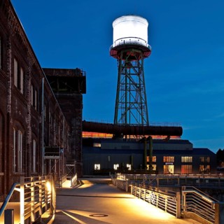Jahrhunderthalle or Centennial Hall with a water tower at dusk