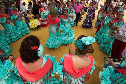 Women wearing gypsy dresses perform traditional Andalusian dances at the Feria del Caballo