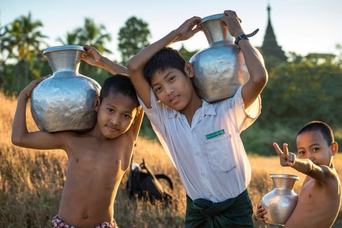 Boys carrying water in water containers made of aluminium